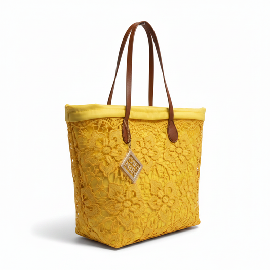 Borsa gialla pizzo dettaglio charm sfondo bianco